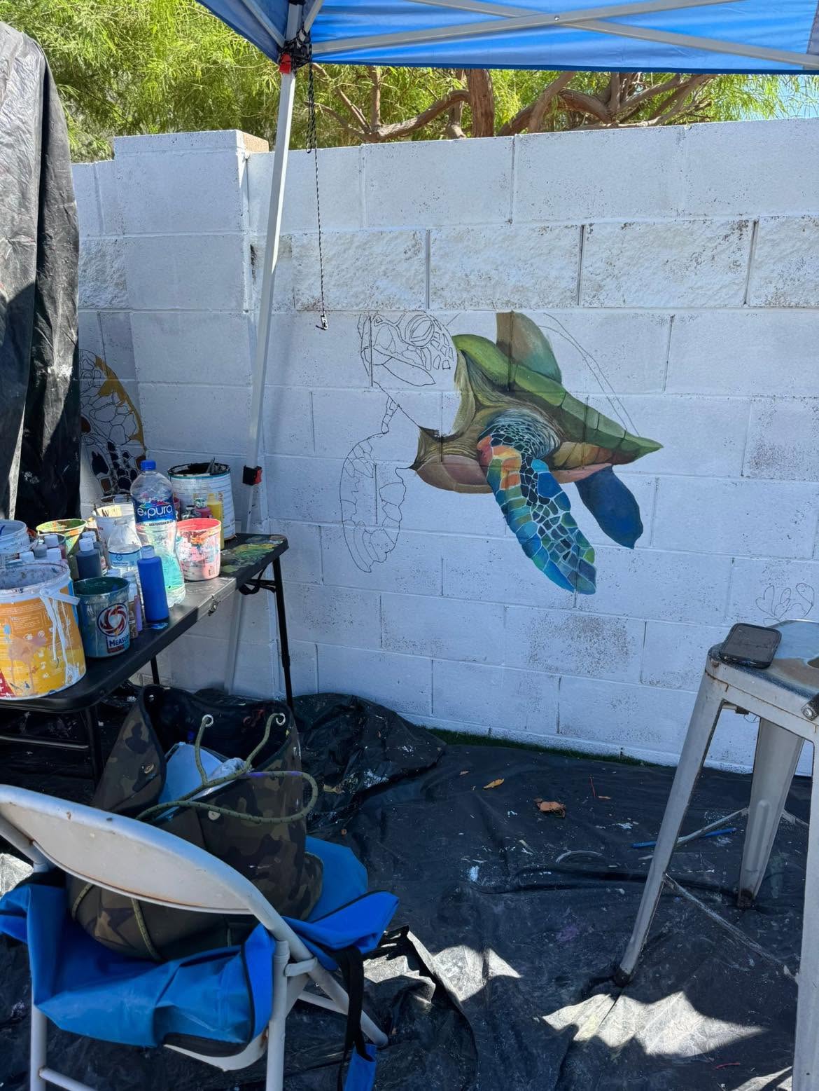 Sea turtle mural in progress, outline and partial color on a cinder block wall